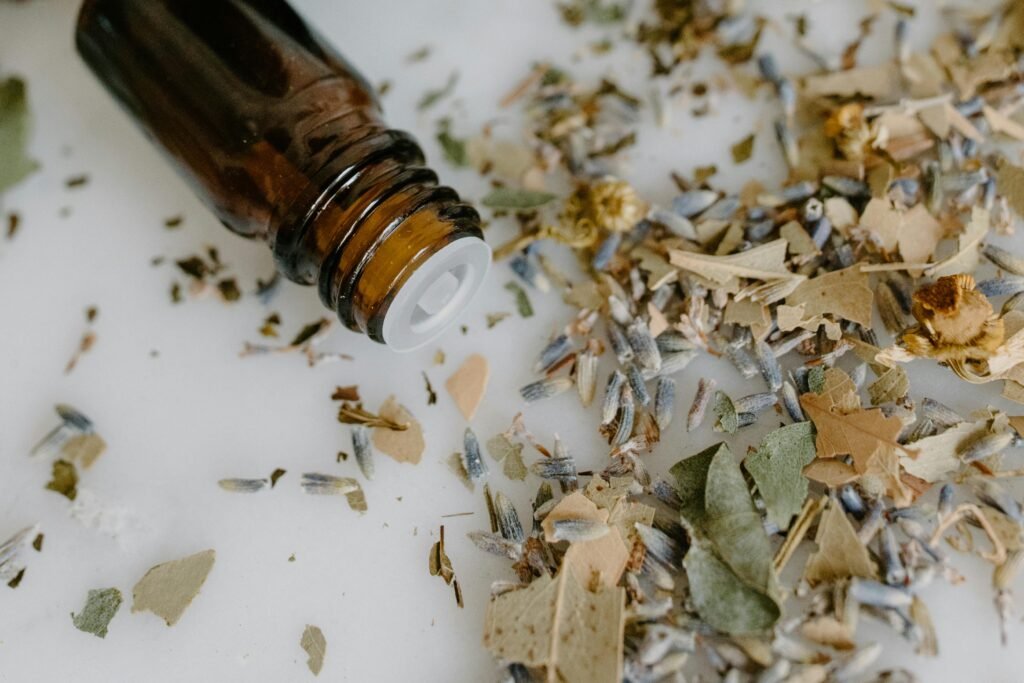 Close-up of a brown glass bottle and dried herbs, ideal for aromatherapy and wellness themes.